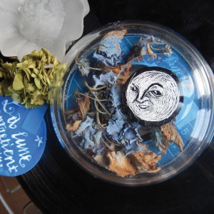 S É R I E “ B O Î T E S D E N U I T” - Série de 12 boîtes de bobines de films (diamètre 18 ou 27,5cm) recouvertes d’un vinyle et de sa lune unique en carte à gratter. “La lune entretient son jardin musical”.